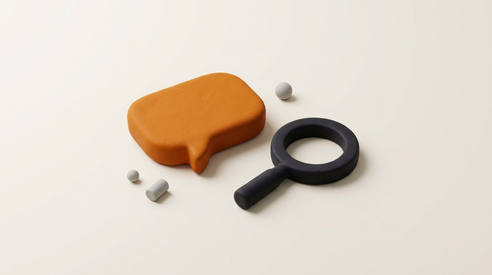 A magnifying glass and a speech bubble shape in orange on grey