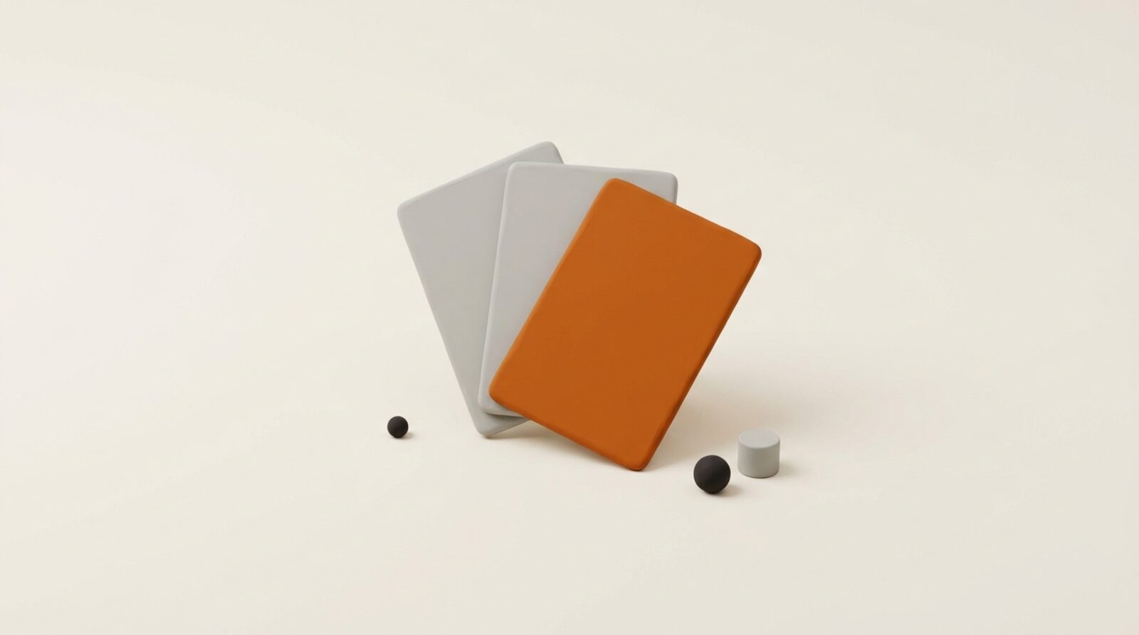 Three matte orange cards fanned out under studio light